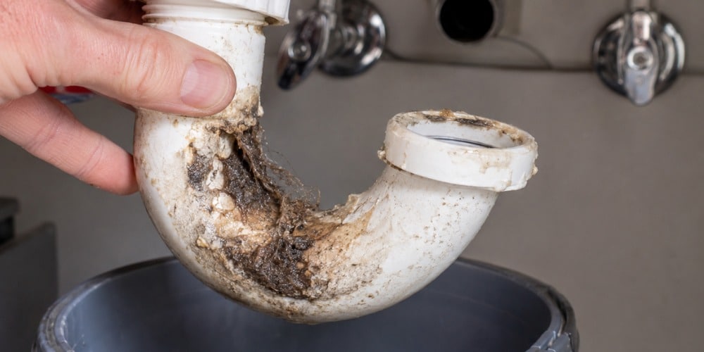 Bathroom sink clog fix showing hair and debris removed from a drain