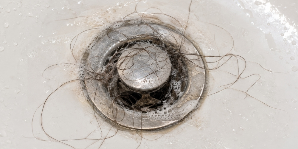 Slow draining bathtub causes including hair and soap buildup around the drain